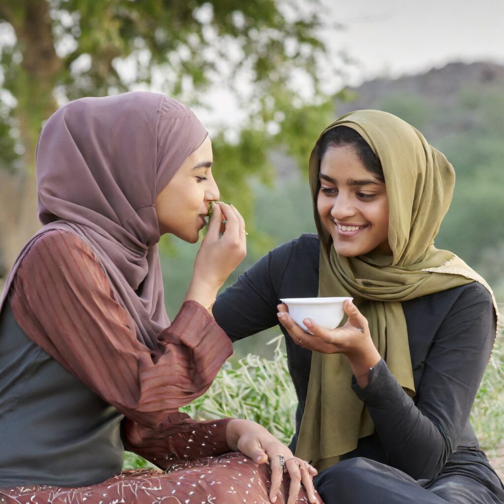 Deux filles boivent un thé sous un arbre dans la nature